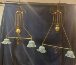 A pair of Rise and Fall Arts and Crafts style brass light fittings with ice blue Vaseline shades,