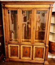 An early 20th century oak glazed display cabinet, lighter oak inlay, three glazed doors, flanked