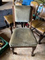 Set of four upholstered dining chairs with brass castors to the front legs
