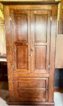 A George III and later oak hall livery cupboard, swept cornice above twin moulded panel doors