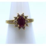 18ct Gold Ruby and Diamond cluster ring.  The oval brilliant cut ruby is 7mm x 5mm.  There are ten