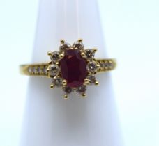 18ct Gold Ruby and Diamond cluster ring.  The oval brilliant cut ruby is 7mm x 5mm.  There are ten