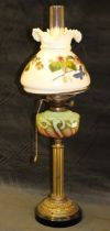 A Victorian brass oil lamp with floral painted opaque glass shade and green glass reservoir, 82cm