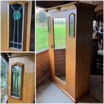 An Arts and Crafts oak wardrobe with stained glass side panels