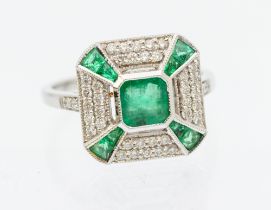 An emerald and diamond 18ct white gold  cluster ring, comprising a square cut emerald to the centre,