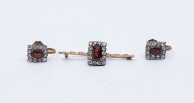 A garnet and white sapphire set gold bar brooch, comprising a rectangular mixed cut garnet within