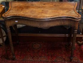 A George III inlaid walnut and mahogany serpentine fold over games / card table, the fold over top