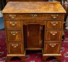 A George II walnut veneered kneehole desk, rectangular moulded top above frieze drawer and central