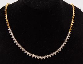 A diamond and 18ct gold necklet, comprising a with white front section set with 31 trefoil motifs of