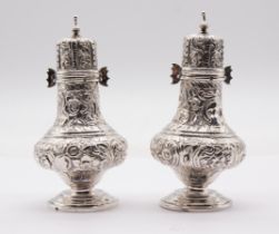 A pair of late Victorian silver pepper pots / castors, baluster shaped profusely chased and engraved