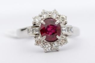 A Burmese ruby and diamond 18 white gold cluster ring, comprising a oval mixed  cut ruby approx 1.