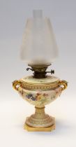 A Royal Worcester porcelain oil lamp, the two handled blush ivory urn shaped body with acanthus