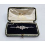 An 18ct. white gold and platinum diamond brooch, the centre set round brilliant cut diamond with