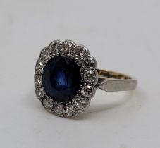 An 18ct. gold, platinum, sapphire and diamond ring, set mixed cushion-cut sapphire to centre (