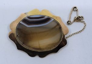 An 18ct. gold mounted agate brooch, set banded oval agate to centre, length 38mm. (gross weight 8.