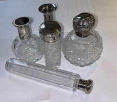 A silver topped scent bottle, (as found), together with three white metal topped vanity bottles