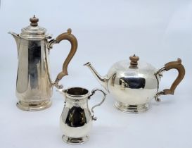 A silver bullet teapot, hot water jug and milk jug, by Goldsmiths & Silversmiths Co Ltd, London