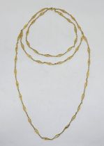 A long precious yellow metal fancy link triple chain necklace, formed from lozenge form filigree