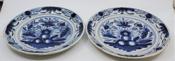 A pair of mid 18th century Dutch Delft plates, painted in blue, diameter 23.4cm. (2) Condition note: