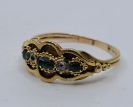 A Victorian precious yellow metal, emerald and diamond ring, the lobed mount textured to recess