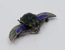 An Egyptian revival unmarked silver, cliosonne and champleve enamel scarab beetle brooch, set