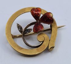 A precious yellow metal, enamel and diamond brooch,  of circular form having scrolling clover to