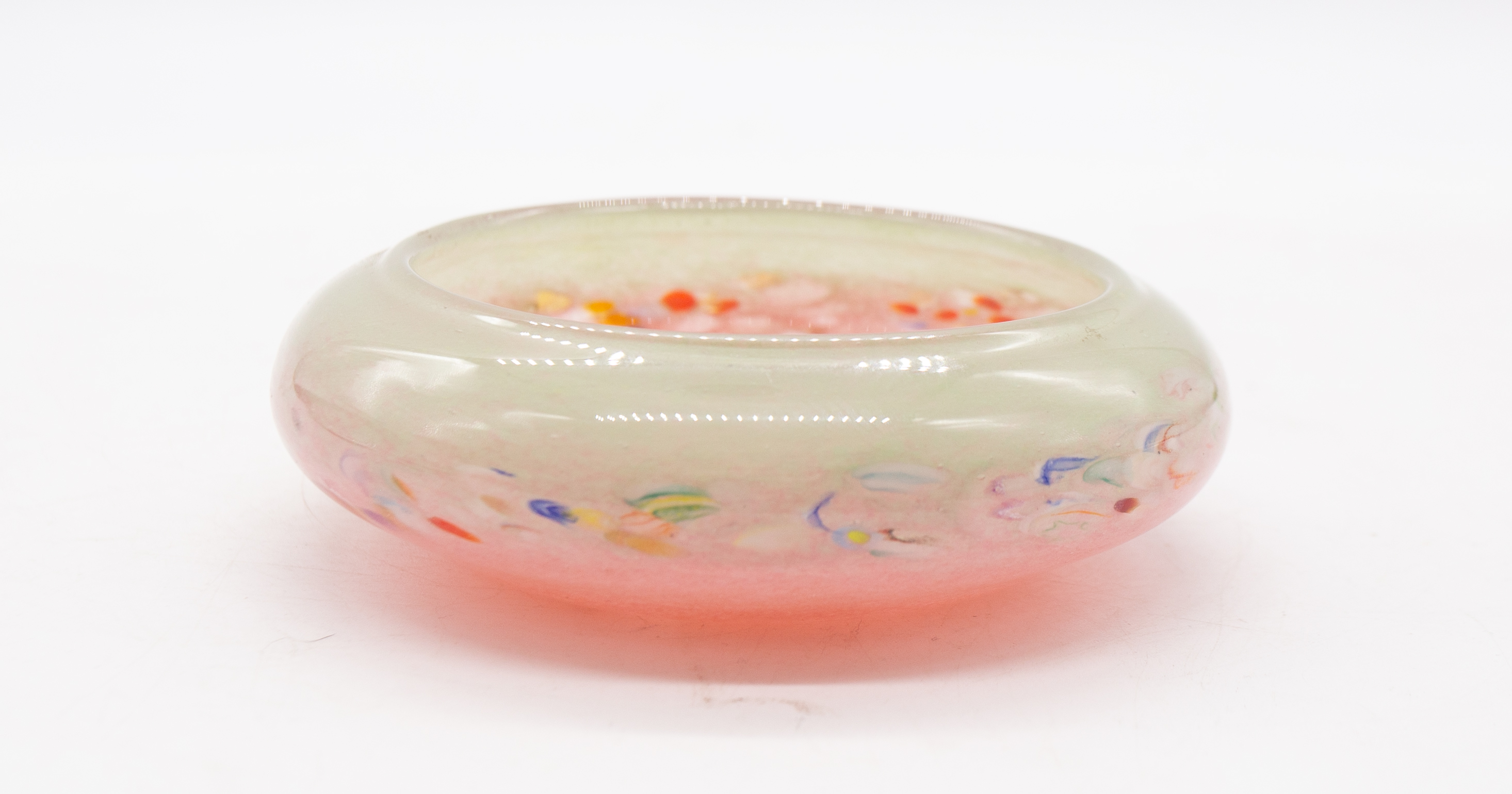 A Monart 20th century small glass circular bowl, having various coloured speckles throughout green