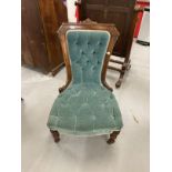 Aesthetic nursing chair with carved framework, upholstered back and seat on turned legs with brass