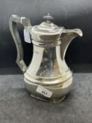 Hallmarked Silver: Hot water jug with black wooden handle and finial, hallmarked London. Weight 22.