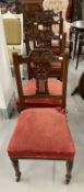 Edwardian mahogany dining chairs with carved backs and turned front supports terminating in castors.