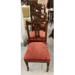 Edwardian mahogany dining chairs with carved backs and turned front supports terminating in castors.