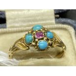 Jewellery: Yellow metal ring set with a single ruby and four turquoise as a floral cluster, tests as