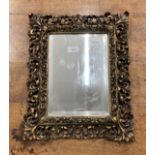 20th cent. Gilt gesso moulded mirror with bevelled glass. 18ins. x 14ins.