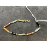 Jewellery: Yellow metal bracelet consisting of cylindrical links of different coloured jade.