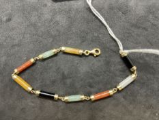 Jewellery: Yellow metal bracelet consisting of cylindrical links of different coloured jade.