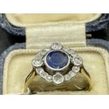 Jewellery: Yellow metal Art Deco circular cluster being a round sapphire, estimated weight 0.75ct,