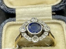 Jewellery: Yellow metal Art Deco circular cluster being a round sapphire, estimated weight 0.75ct,