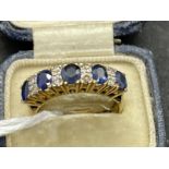 Jewellery: Yellow metal thirteen stone half hoop consisting of five oval cut sapphires, estimated