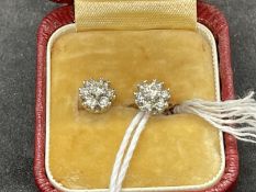 Jewellery: Pair of white metal floral cluster stud earrings each peg set with seven brilliant cut
