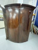 Late 18th cent. Mahogany bow front corner cupboard, moulded cornice above two doors flanked by