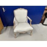 20th cent. French style open arm chair with blue upholstery and piping over a limed finish.