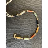 Jewellery: Yellow metal bracelet consisting of cylindrical links of different coloured jade.