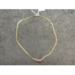 Jewellery: Yellow metal S link chain with a V shaped drop set with seven graduated marquise cut