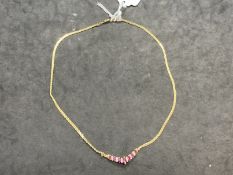 Jewellery: Yellow metal S link chain with a V shaped drop set with seven graduated marquise cut