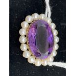 Jewellery: Yellow metal oval brooch set with a 22mm x 16mm oval cut amethyst surrounded by