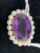 Jewellery: Yellow metal oval brooch set with a 22mm x 16mm oval cut amethyst surrounded by