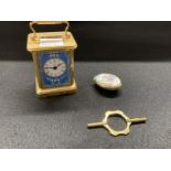 Halcyon Days brass cased miniature carriage clock, enamels with white enamelled dial, Roman