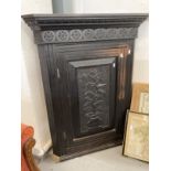20th cent. Oak corner cupboard, a single door opens to reveal three shaped shelves, the carved
