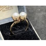 Jewellery: Yellow metal crossover ring set with two cultured pearls, tests as 9ct gold. Ring size