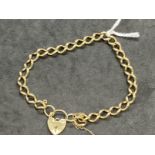 Hallmarked Jewellery: 9ct gold curb link bracelet with padlock fastener. Length 9ins. Width 7mm.